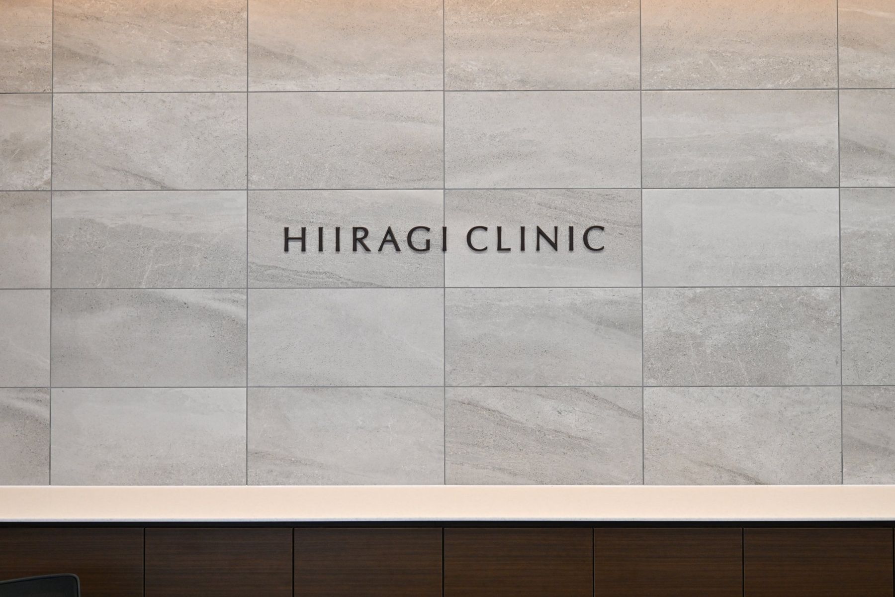 受付の壁に掲げた HIIRAGI CLINIC のサイン